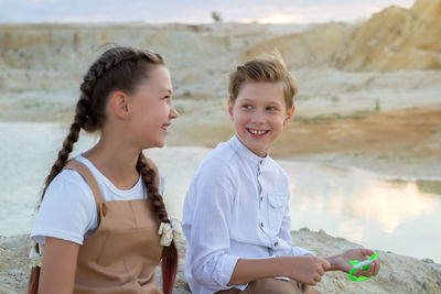 Portrait of smiling friends standing at beach