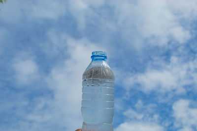 Low angle view of water bottle against blue sky