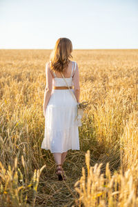 Rear view of woman standing in farm