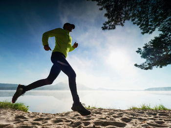 Run on beach. runner along lake. misty morning spent on beach at lake in natural park.