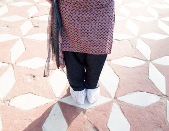 Low section of woman standing on tiled floor