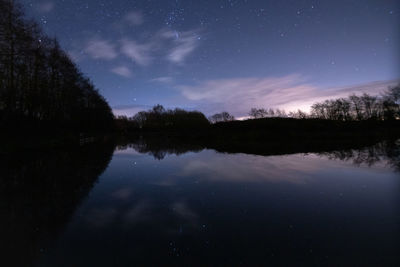 Scenic view of lake against sky at night