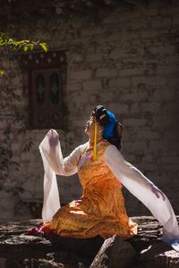 Rear view of woman sitting outside building