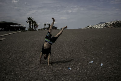 Man doing handstand on land