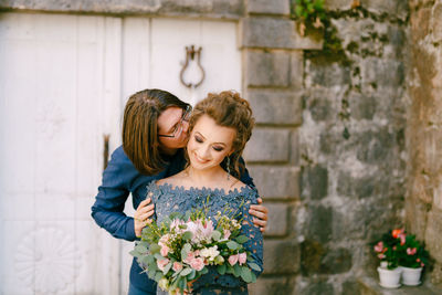 Young couple standing against wall