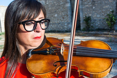 Close-up of woman playing violin on sunny day