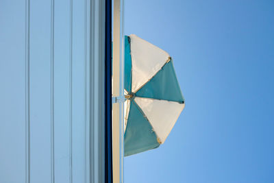 Low angle view of umbrella against clear blue sky