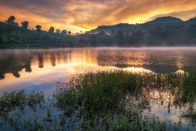 Scenic view of lake against sky at sunset