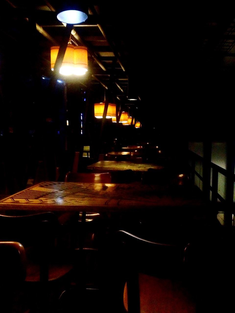 illuminated, indoors, night, lighting equipment, dark, empty, absence, electric lamp, lit, light - natural phenomenon, chair, electric light, table, lamp, glowing, restaurant, home interior, no people, electricity, light
