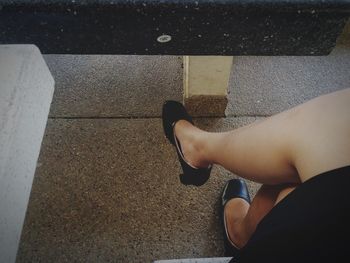 Low section of woman sitting on road