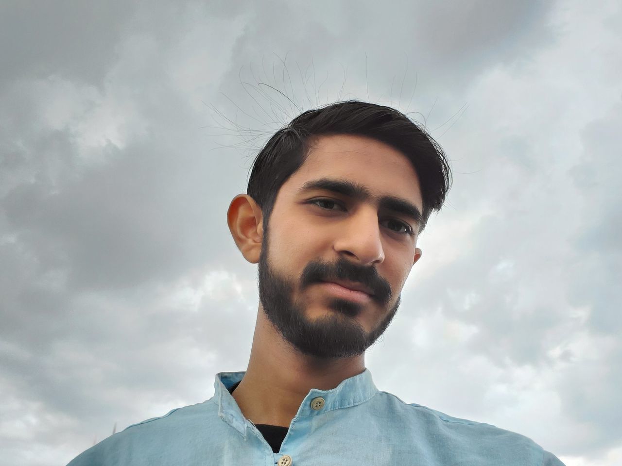 portrait, headshot, cloud - sky, one person, young adult, young men, sky, looking at camera, low angle view, real people, front view, beard, facial hair, lifestyles, nature, leisure activity, casual clothing, men, day, human face