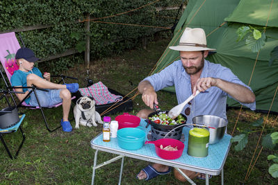 Man preparing food in front of tent