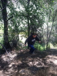 Young man on field in forest