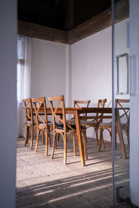 Stylish modern loft dining area with bare concrete wall with  wood table and chairs  interior design