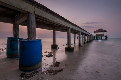 Pier over sea against sky during sunset