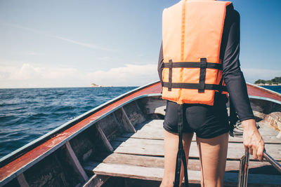 Rear view of man standing on boat