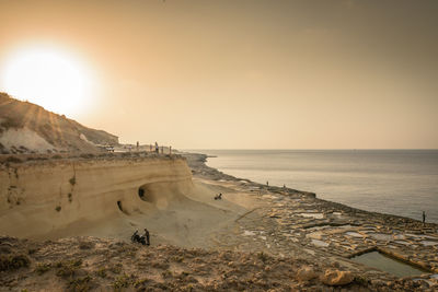 High angle view of rock formation on sand at beach during sunset