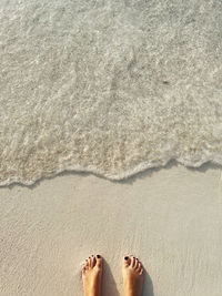 Low section of person standing on sand at beach feet 