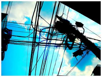 Low angle view of power lines against blue sky