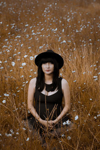 Portrait of young woman wearing hat on field