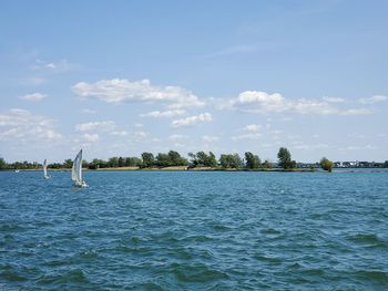 Scenic view of sea and boats against sky