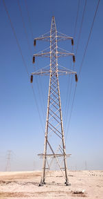 Low angle view of power lines against clear blue sky