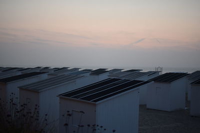 Houses in town against sky during sunset