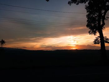 Scenic view of silhouette landscape against orange sky