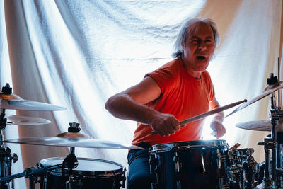 Man playing drum at home