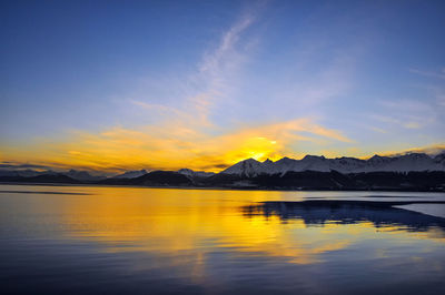 Scenic view of lake against sky at sunset