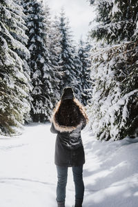 Woman standing by trees during winter