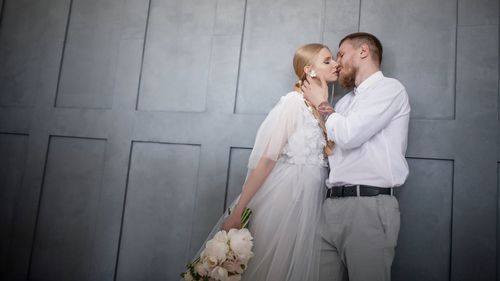 Couple kissing against wall