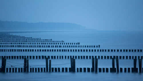 Swimming pool by sea against blue sky