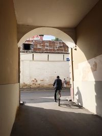 Rear view of woman walking on building