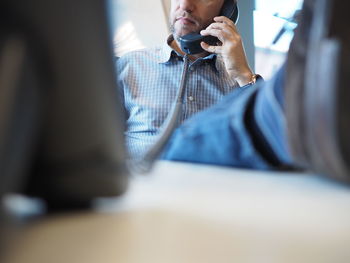 Midsection of man using mobile phone