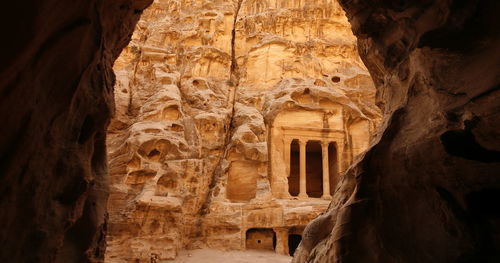 Low angle view of old structure seen through cave at petra