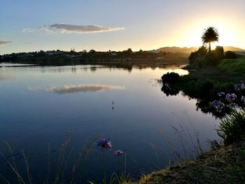 Scenic view of lake against sky at sunset