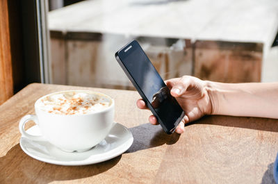 Close-up of woman's hand holding mobile phone