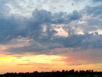 Silhouette of trees against dramatic sky