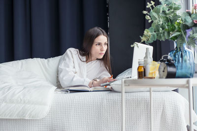 Portrait of young woman sitting on table