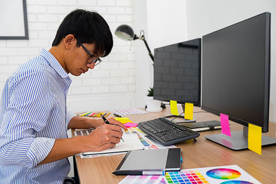 Side view of senior man using smart phone on table