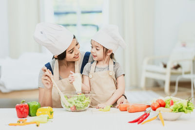 Midsection of woman having food in kitchen