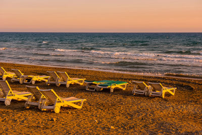 White sunbeds in a sandy beach at sunset. summer vacation concept. toned and saturated image