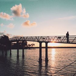 Silhouette of people in water at sunset