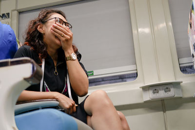 Young woman is sitting on a train smiling