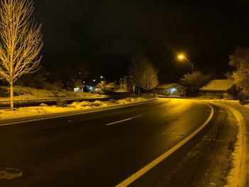 View of illuminated street in city at night