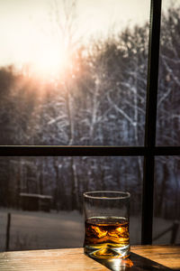 Close-up of beer glass on window sill