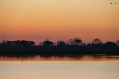 Scenic view of lake against romantic sky at sunset