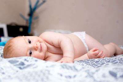 Baby boy lying on bed