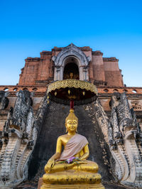 Low angle view of statue against temple building